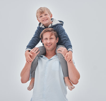 Family, children and beach with a father and son outside on an overcast day against a gray background while on vacation together. Summer, freedom and travel with a man on boy on a coastal holidayの写真素材