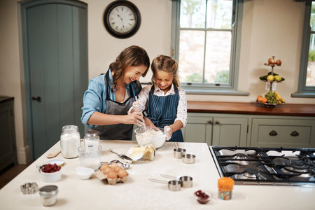 Baking is love made visible. a woman and her daughter baking together in the kitchen.