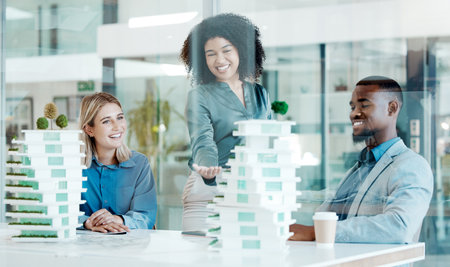 Architect, meeting and planning with a team at work in their office for design or building. Teamwork, model and collaboration with an architecture group working together on an engineer projectの写真素材