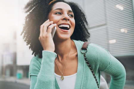 Happy, phone call and black woman in a street, smile and talking while walking in city in New York. Student, travel and laughing with girl chatting on a phone, excited and cheerful while travelingの写真素材