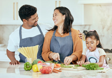 Cooking, kitchen and family with a girl, mother and father preparing food for a meal in their home together. Children, health and diet with a man, woman and daughter making dinner in a houseの写真素材