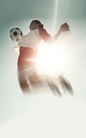 Soccer player, ball chest and jump in blue sky, sunshine or outdoor training for match, football or game. Health, energy and male from India leap, spring or jumping high in air for sports workout.の写真素材