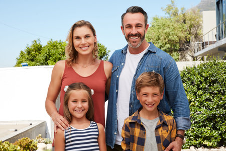 Welcome to our home. Portrait of a happy young family spending quality time in their backyard at...