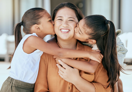 Love, mother and girls kiss, hug and happy together with smile and bonding. Portrait, mama and children with embrace, being loving and happiness with proud female parent and connect with kidsの写真素材
