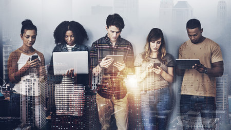 Were all connected on way or another. Studio shot of a group of young people using wireless...