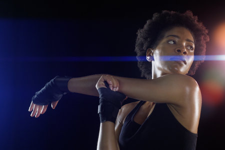 i guess Im stretching it a bit too far today. Studio shot of a young sportswoman posing against a dark background.の写真素材