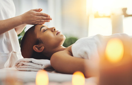 Massage away the stresses of the day. an attractive young woman getting a massage at a spa.の写真素材