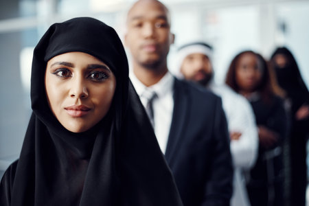 Im at the head of the queue. Cropped portrait of an attractive young arabic businesswoman standing at the head of a line of her colleagues.の写真素材