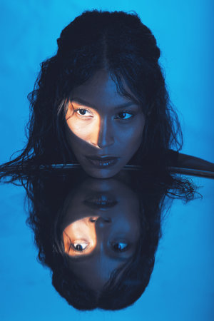 Beauty, woman and light on face reflection with mirror for edgy cosmetics, skincare or advertising....