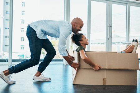 Bringing some splashes of fun into their home. a young couple having fun while moving house.の写真素材