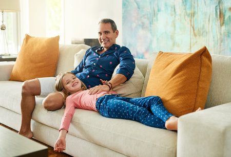 She means the world to me. Full length portrait of a mature man and his daughter on the sofa at home.の写真素材