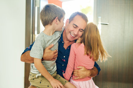 We missed you, daddy. a mature man greeting his kids at the front door after arriving home from work.の写真素材