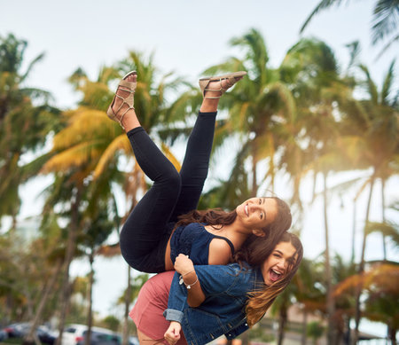 Living life with my best friend. two female best friends being playful in a public park.の写真素材