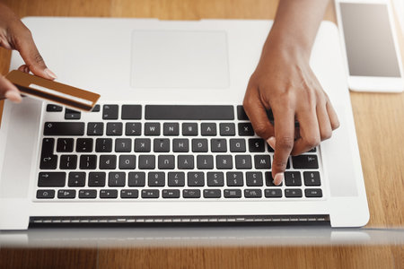 Payments being made with just a click. High angle shot of an unrecognizable businesswoman shopping online in her home office.の写真素材