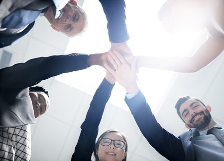 Theres nothing we cant achieve together. Low angle portrait of a team of happy colleagues putting...