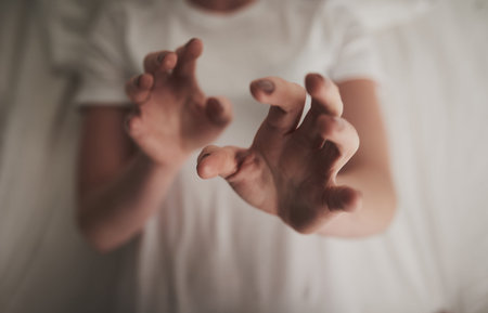 Reach out and touch me. High angle shot of an unidentifiable young woman holding up her hands in a...