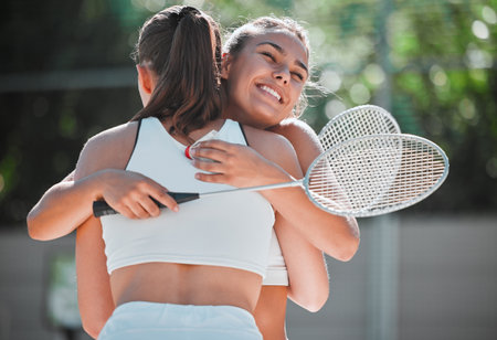 Badminton, happy and sports friends hug together for bond, love and care with smile on game break. Exercise, workout and happiness in women friendship with embrace on outdoor summer court.の写真素材