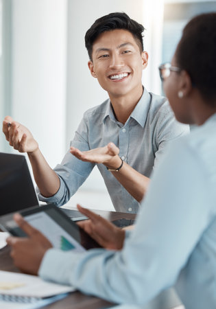 Asian businessman, hand gesture or talking in teamwork meeting, digital marketing collaboration or strategy planning. Technology, smile or happy creative workers or designers with target audience kpiの写真素材