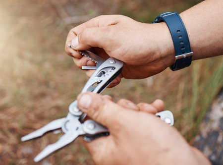 Man hands use multi purpose knife for camping, outdoor survival and adventure in park, woods and scouts hiking. Sharp pocket tool, practical accessory and handy steel utility equipment for hiker guyの写真素材
