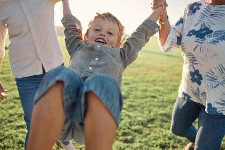 Happy, grass and child holding hands with parents on nature walk in a field on a summer holiday. Family, support and love, happiness in fun quality time with young boy walking and playing on vacationの写真素材