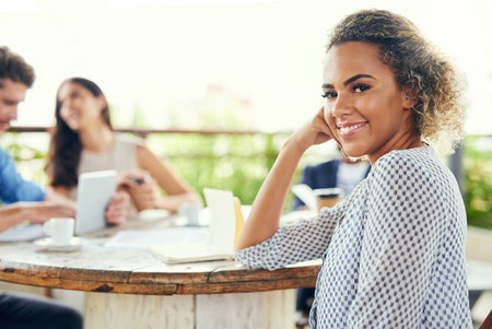 Weve been generating some fresh new ideas outdoors. Portrait of a young businesswoman having a meeting with her colleagues outdoors.の写真素材