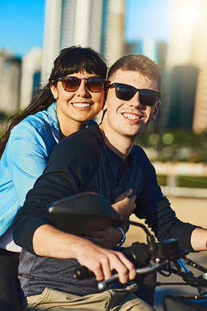 Getting around town in a fun way. a young couple out for a ride in the city.の写真素材