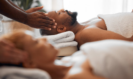Relax man, head massage and couple on spa massage table for facial, wellness and stress relief therapy. Salon therapist hands touch face, scalp or healing sleeping black man for cosmetic healthy skinの写真素材