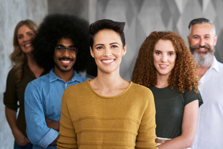 Nothing is achieved without teamwork. Cropped portrait of a group of designers standing in their creative office.の写真素材