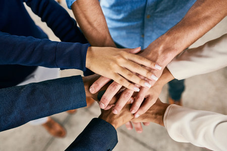 Their motivation runs high in this team. Closeup shot of a group of people joining their hands in a...