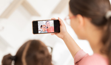 Family phone selfie, mother and girl at optometry hospital taking picture for happy memory together....