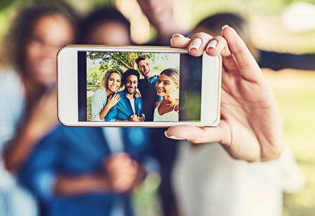 The memory will never fade. two happy young couples taking a selfie together outdoors.の写真素材