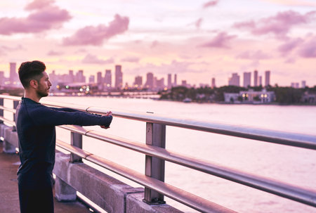 Preparing to get into the fitness zone. a handsome young man exercising outdoors.の写真素材