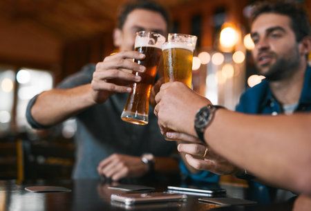 Heres to a successful business in the future. three cheerful young men having a celebratory toast with beer while sitting at a table inside of a beer brewery during the day.の写真素材