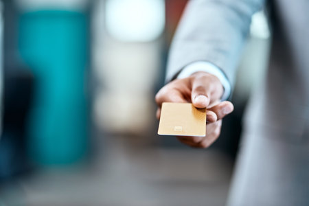 Keep personal expenses from professional expenses with a business account. Closeup shot of an unrecognizable businessman holding a credit card in an office.の写真素材
