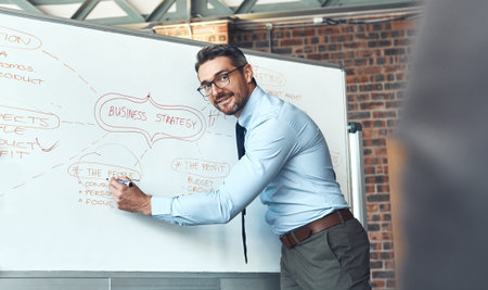Ensuring everyone understands the big plan. a mature businessman using a whiteboard during a...