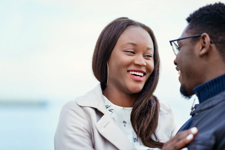 An affectionate young couple bonding together outdoors.