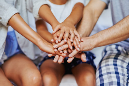 Were in this, together. Closeup shot of an unrecognizable family of three with their hands in a...