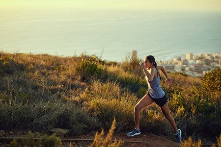 Im going to beat this trail. a young woman out for a run along a mountain trail.