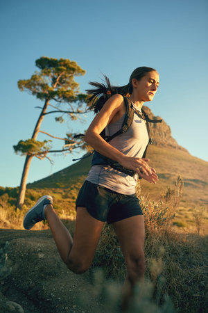 Ill reach my goal, no matter what. a young woman out for a run along a mountain trail.