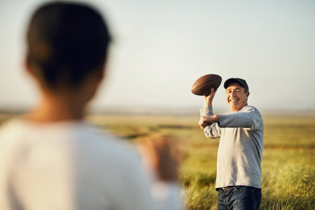 We love the game. father and son playing football on an open field.の写真素材