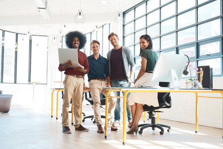 Well be your design dream team. Portrait of a team of happy designers working at a desk in their...