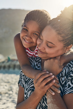Portrait of a little girl bonding with her mother at the beach.の写真素材
