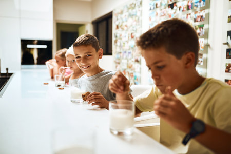 Its yummy. Portrait of little siblings enjoying a glass of milk with cookies at home.の写真素材
