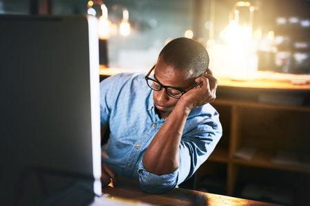 He should have logged off a long time ago. an exhausted young businessman sleeping at his desk...