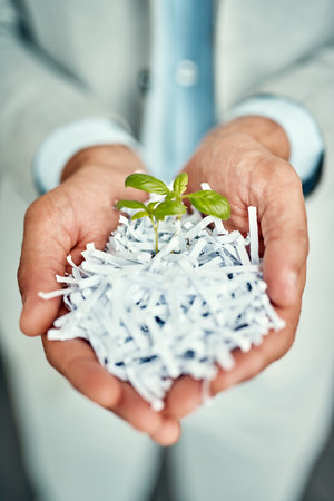 From the old grows the new. High angle shot of an unrecognizable businessman holding a budding...