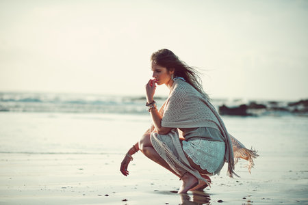 Contemplate in the comfort of the sea. an attractive young woman spending a day at the beach.の写真素材