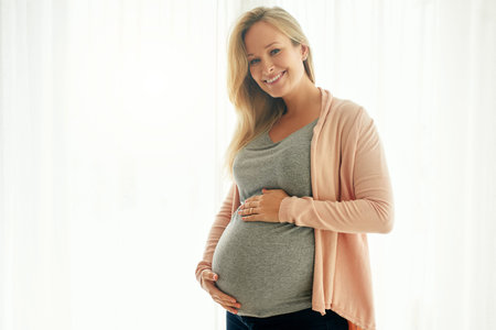 I love every minute of being pregnant. a beautiful woman holding on to her pregnant belly.