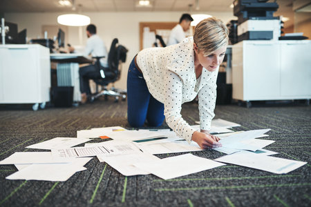 Another productive day with paperwork. a businesswoman working with paperwork on the floor in the...