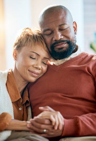 Senior black couple, holding hands on sofa or comfort bonding care with smile happiness in home...