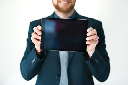 Trust me, youll need it. an unrecognizable businessman holding up a digital tablet.の写真素材